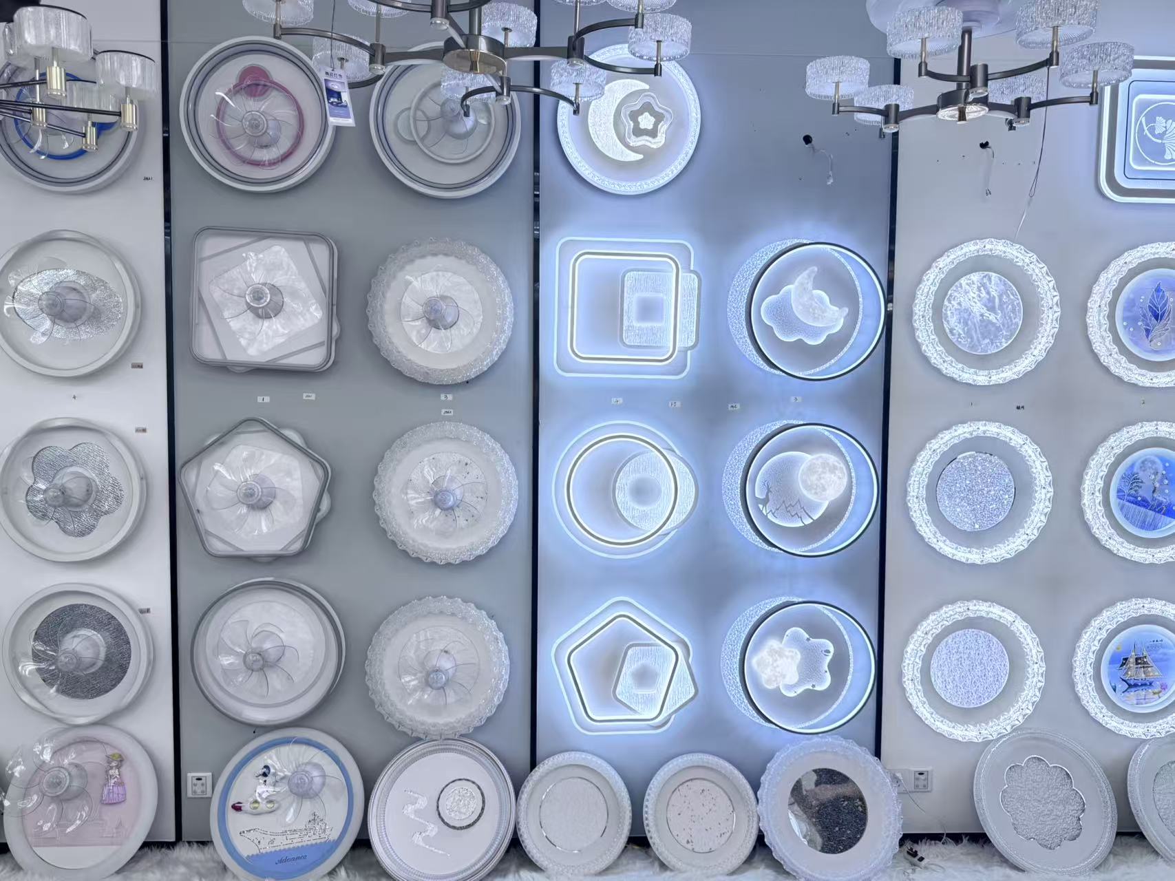 Wide wall of illuminated ceiling-light samples in the FIFTH & BEAM Guzhen showroom