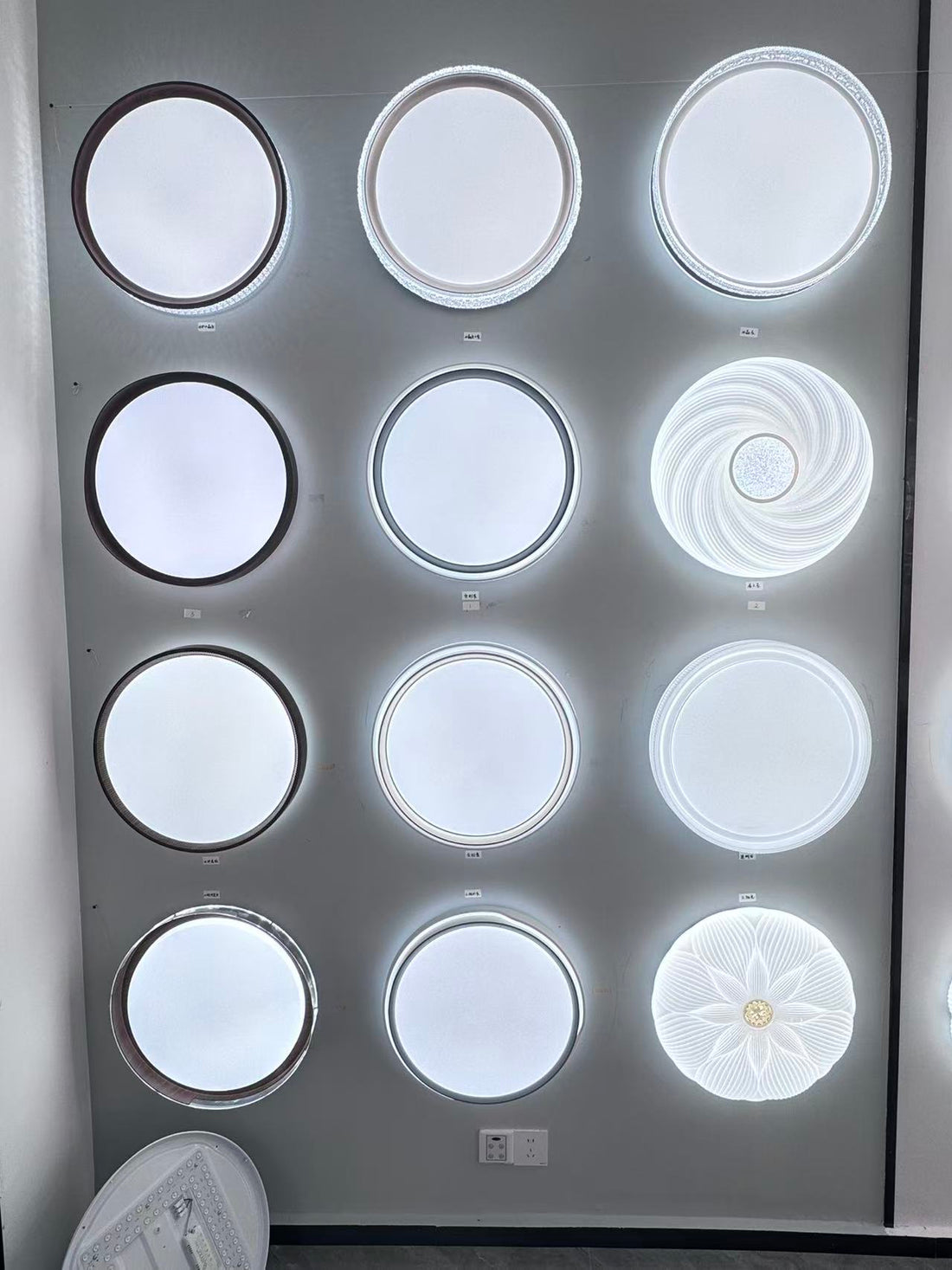 Round low-profile ceiling-light samples displayed for comparison in the FIFTH & BEAM Guzhen showroom