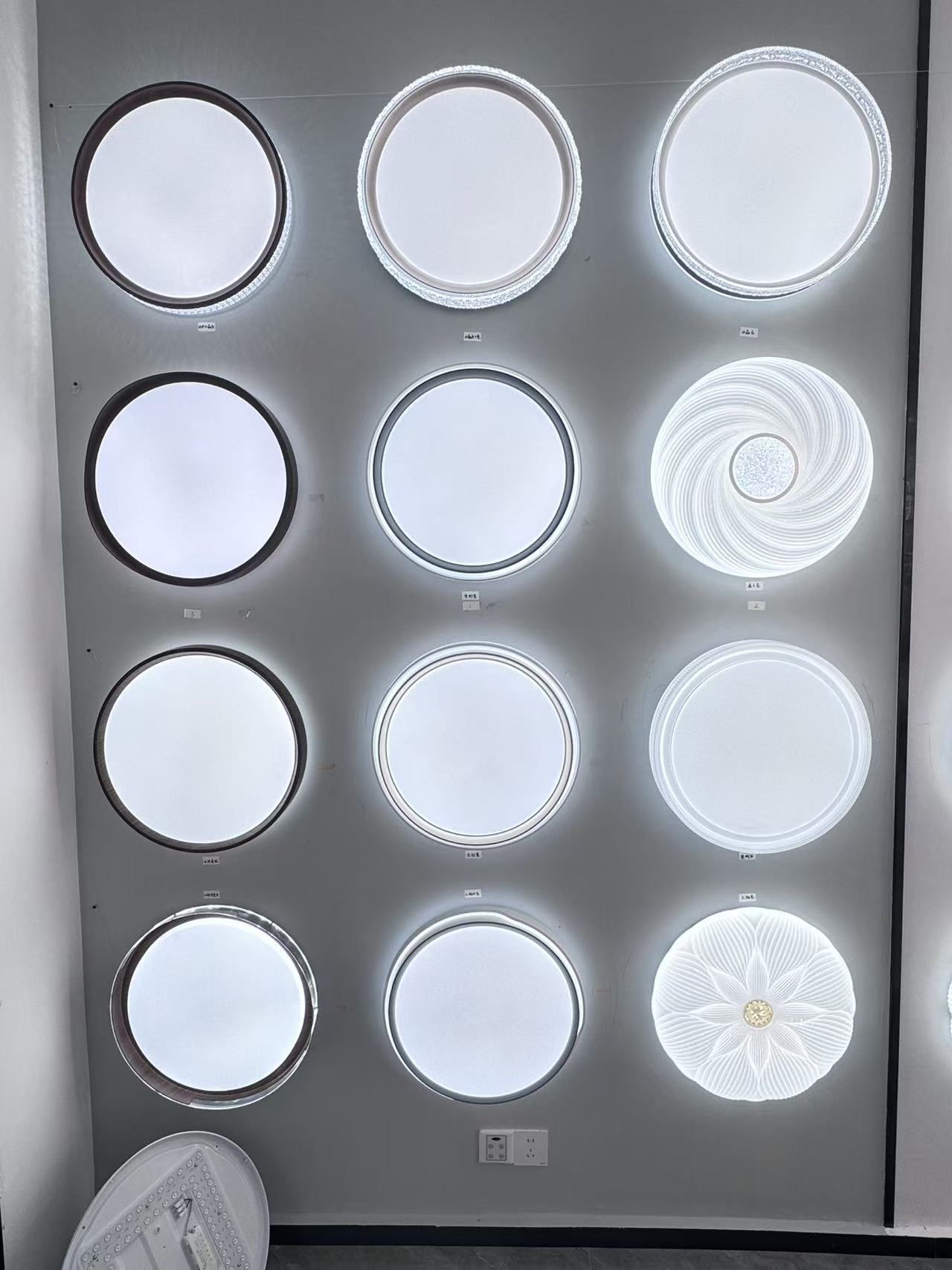 Round ceiling-light samples displayed for comparison in the FIFTH & BEAM Guzhen showroom